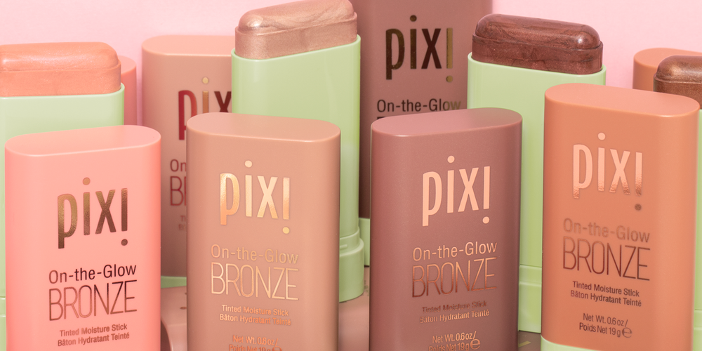 Multiple packages of On-The-Glow BRONZE on a pink background