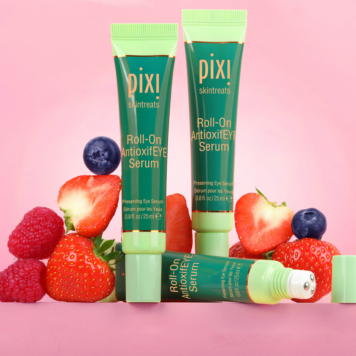 Pixi Roll-On Antioxidant Eye Serum with strawberries and blueberries on a pink background